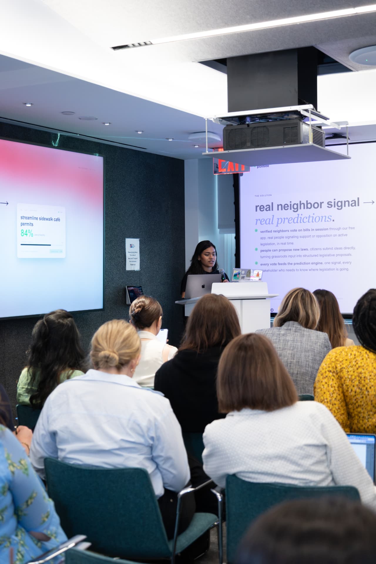 Founder presenting on stage at a Women in AI Pitch Competition event