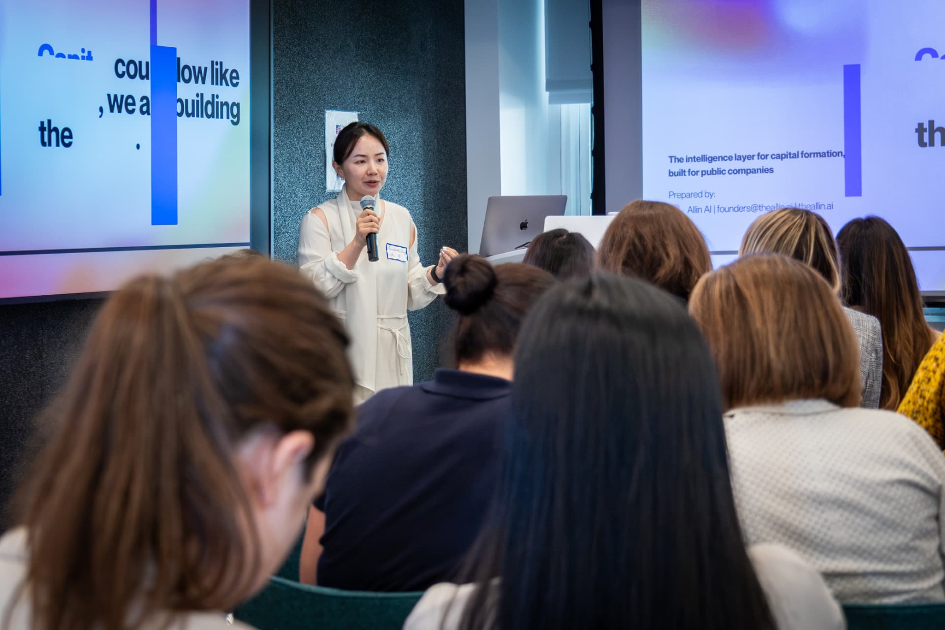 A founder pitching on stage to a full room